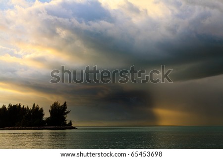 Thunder storm with rain lit by the sun at a lake