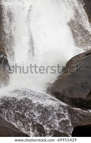 Water falling on the rocks in close up