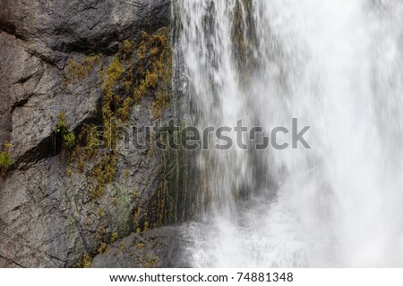 Water falling on the rocks in close up