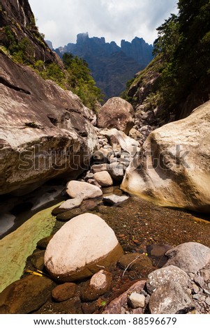 Dry riverbed with mountains in the background on a sunny day