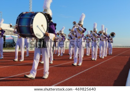 Blur purple white uniform marching band in sport day parade on \
stadium in Chaiyaphum Rajabhat University Thailand