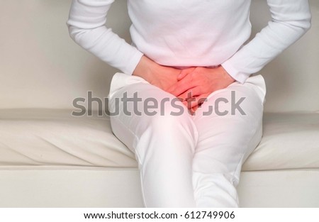woman with hands holding her crotch in pain.\
Bladder pain.
