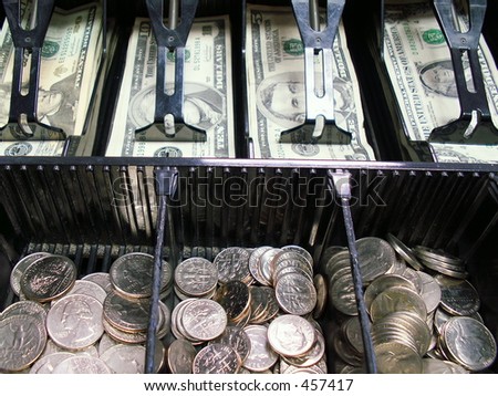 open cash register with bills and change showing with focus on bills.