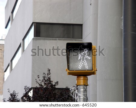 pedestrian crossing signal on a pole with out of focus building in background