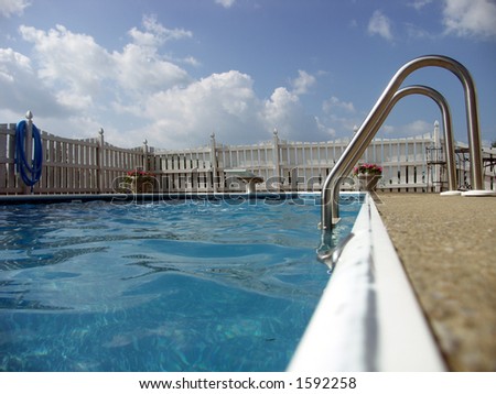 Ladder and diving board of an inground pool. Focus on ladder.