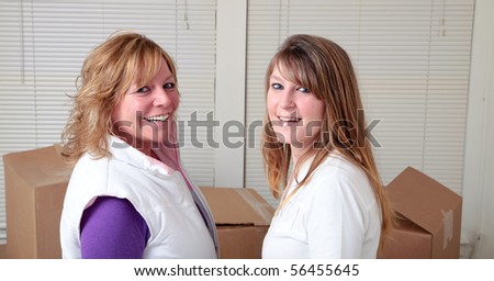 Female roommates in front of moving boxes.