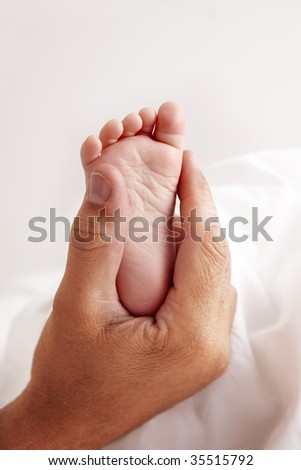 Baby feet in dads hand