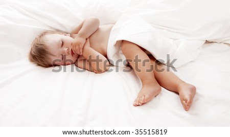 Baby lying in white sheets