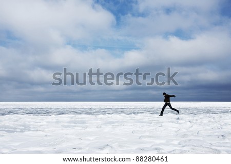 Man running in snow in winter landscape