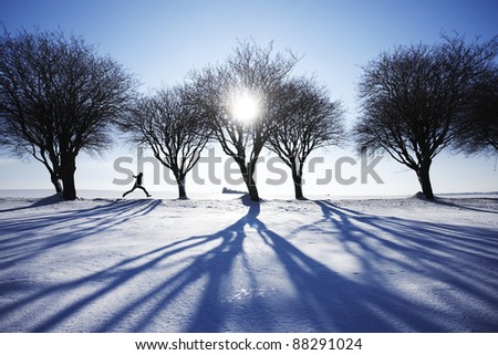 Man running in snow in winter landscape