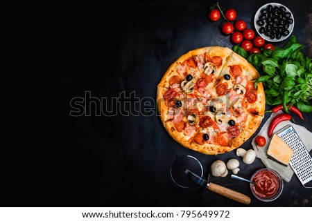 Traditional Italian pizza, vegetables, ingredients on a dark metallic background. Pizza is cooking in the oven. Pizza menu. View from above. Space for text.