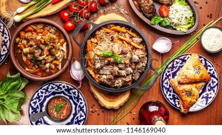 Traditional Uzbek oriental cuisine. Uzbek family table from different dishes for the New Year holiday. The background image is a top view.