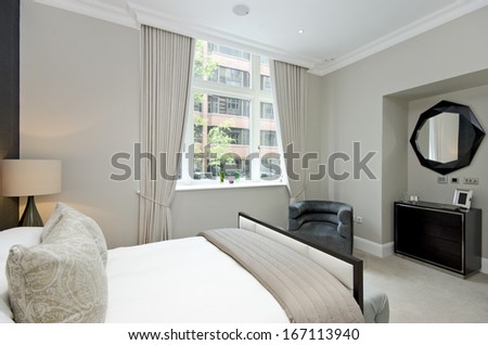 Contemporary and luxutious double bedroom with large bed and contemporary designer furniture