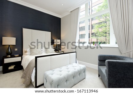 Contemporary and luxutious double bedroom with large bed and contemporary designer furniture