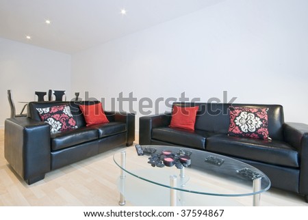 modern living room with leather sofas, cushions and glass coffee table