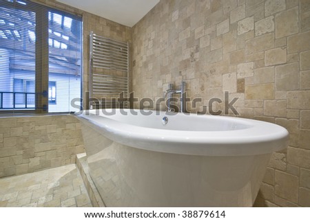 detail of the modern bath with natural floor to ceiling stone tiles
