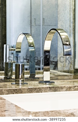 detail of a modern marble top hand wash basin with chrome water mixer tap
