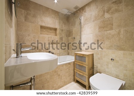 modern luxury bathroom with beige marble stone tiles and white ceramic suite