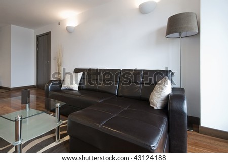 modern living room with large leather corner sofa and a glass coffee table