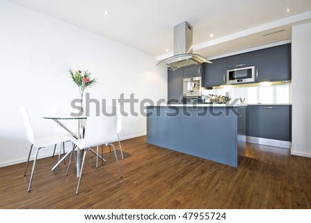 Modern open plan living area with dining table and fully fitted kitchen