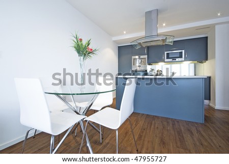 Modern open plan living area with fully fitted kitchen and a dining table for four