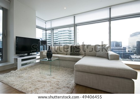Contemporary living room with designer furniture, floor to ceiling windows and panoramatic views