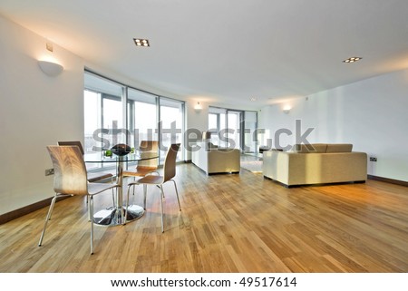 Modern penthouse living room with large designer sofas and dining table and chairs