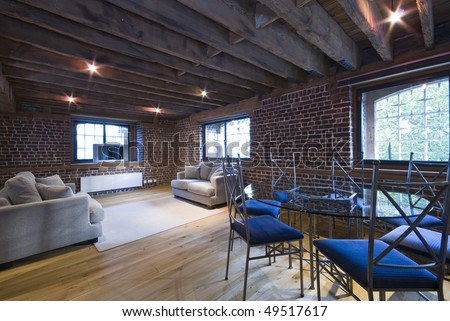 Warehouse conversion contemporary living area with large sofas and dining table for seven