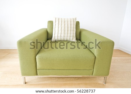 Detail of a modern green armchair isolated on white backround and laminated floor
