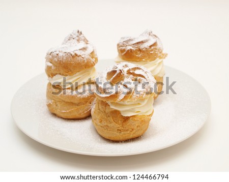 Choux pastry buns, filled with whipped cream, on a plate