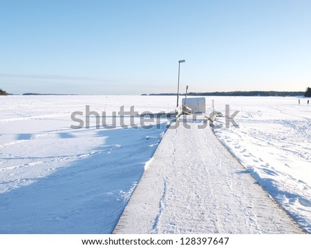 Ice swimming place, pier covered with snow, blue sky