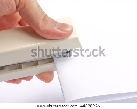 A hand stapling paper, on white background