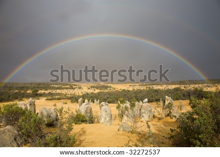 Full rainbow over pinnacles national park. Dark sky and rainbow over the yellow sand create a great atmosphere.