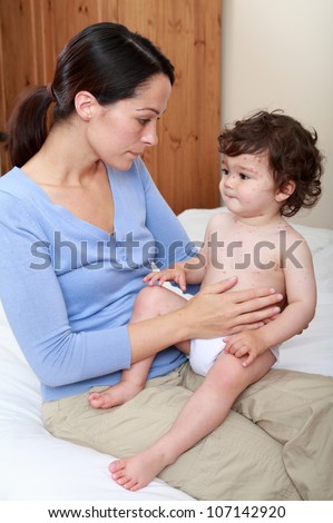 Mother comforting baby with chicken pox