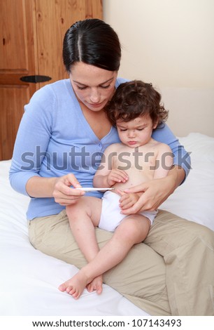 Mother taking babies temperature