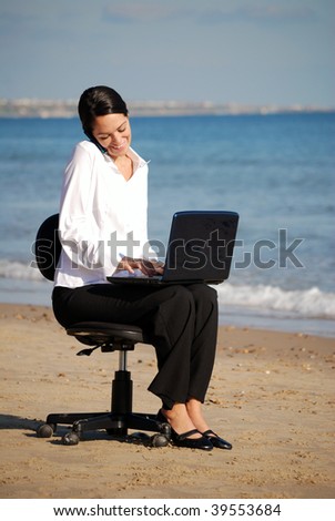 Business woman multi tasking at beach