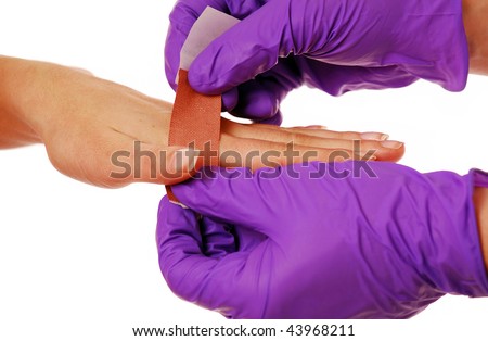 First aider putting on a plaster wearing gloves isolated on white