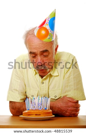 stock photo : Senior male blowing out many candles on birthday cake