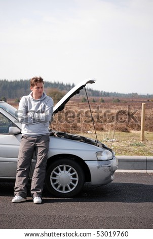 Man waiting by broken down car