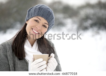 Woman holding hot drink outside in the snow