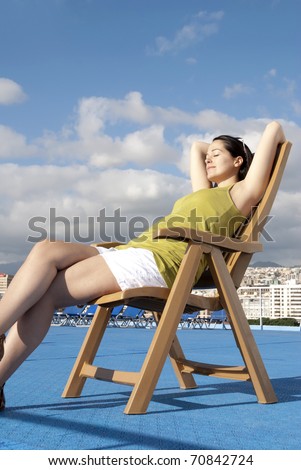 Woman relaxing at sea on deck chair