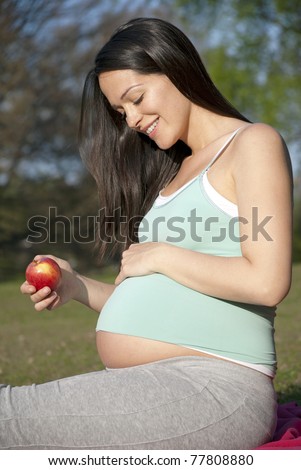 Pregnant woman holding apple