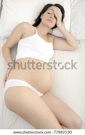 Pregnant woman suffering from bad back in bed