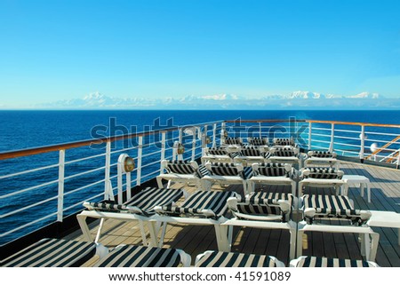 Deck of a cruise ship with rows of lounge chairs