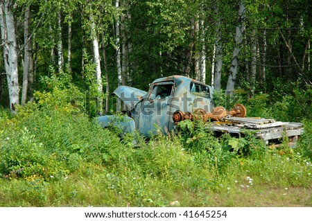 Old rusted pickup truck sitting in a field