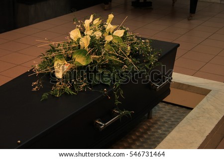 Wooden casket with funeral flowers, cremation ceremony