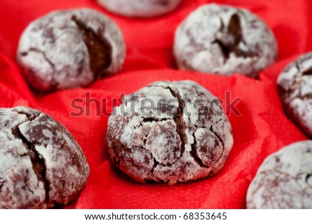 Chocolate biscuits covered with icing sugar on red napkin