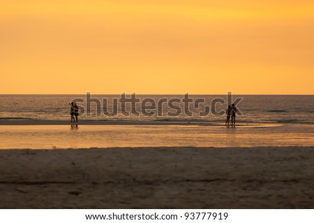 Separate two couple peoples on the beach at sunset