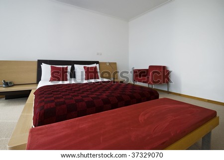 huge double bed with bedside table and purple sheets