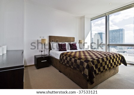contemporary double bedroom with floor to ceiling windows and city views